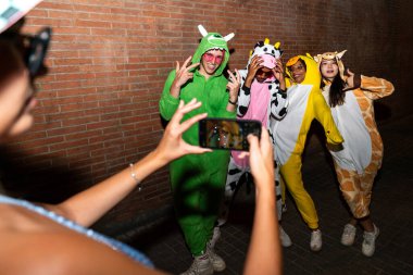 Çoklu etnik gruptan bir grup genç gece sokaklarda eğleniyor şık, çok kültürlü, komik kostümler giyen insanlar bir disko kulübünde partiden önce takılıyor.