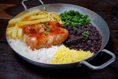 Et ve pirinçli siyah bir tabak Brezilya yemeği. Brezilya yemeği konsepti.