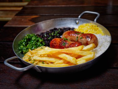 Brezilya mutfağı, tavuklu pilav ve sebzeli ahşap tavada. en üstteki görünüm.