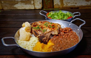 Pirinçli biftek, fasulye, mısır, fasulye, tahtadan bir masada mısır..