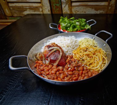 Biftek ve sebzeli bir kase pirinç.