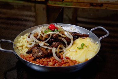 fasulye, pilav, patates püresi, kızarmış et ve soğan dilimleri. 