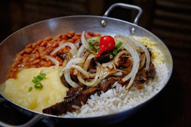 fasulye, pilav, patates püresi, kızarmış et ve soğan dilimleri. 