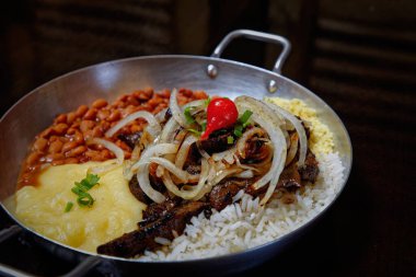 fasulye, pilav, patates püresi, kızarmış et ve soğan dilimleri. 