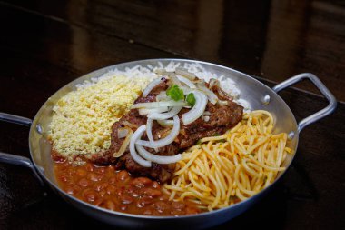 Brezilya bifteği, soğan, fasulye, pirinç ve farofa.