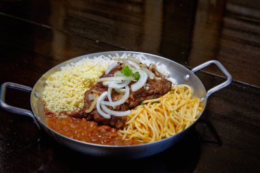 Brezilya bifteği, soğan, fasulye, pirinç ve farofa.