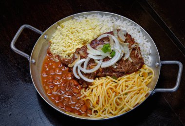 Brezilya bifteği, soğan, fasulye, pirinç ve farofa.