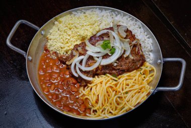 Brezilya bifteği, soğan, fasulye, pirinç ve farofa.