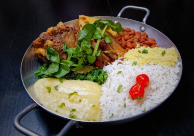 Brezilya bifteği, su tereli öküz kuyruğu, fasulye, farofa, pirinç ve biber.