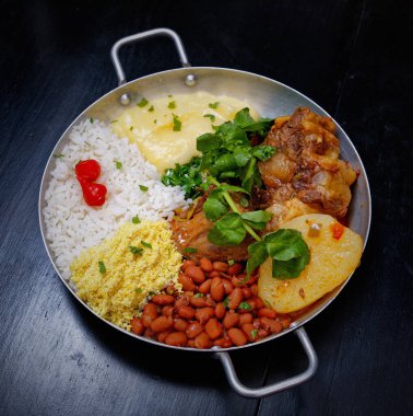 Brezilya bifteği, su tereli öküz kuyruğu, fasulye, farofa, pirinç ve biber.