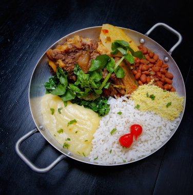 Brezilya bifteği, su tereli öküz kuyruğu, fasulye, farofa, pirinç ve biber.