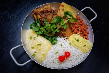 Brezilya bifteği, su tereli öküz kuyruğu, fasulye, farofa, pirinç ve biber.