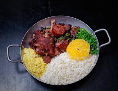 Sosis, lahana, pirinç ve portakallı Brezilya feijoadası.