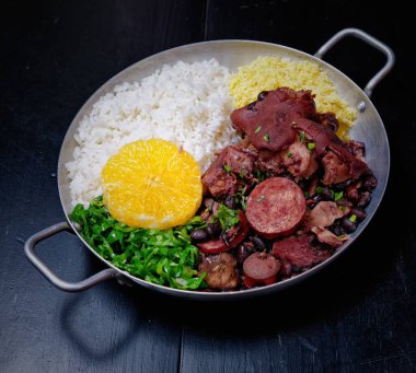 Sosis, lahana, pirinç ve portakallı Brezilya feijoadası.
