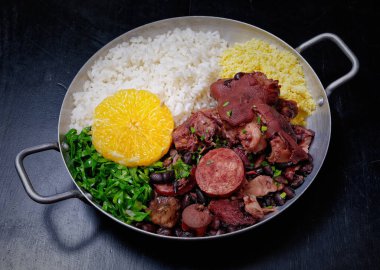 Sosis, lahana, pirinç ve portakallı Brezilya feijoadası.