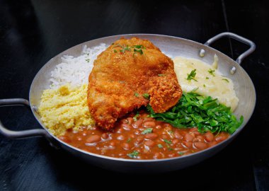 Sosis, lahana, pirinç ve portakallı Brezilya feijoadası.