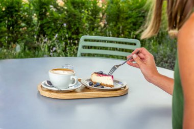 Kahvaltı için kahve dükkanında kapuçinolu yaban mersinli kek.