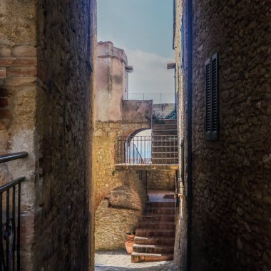 The old narrow streets in the medieval town of Casale Marissimo in Tuscany shot with analogue film technique clipart