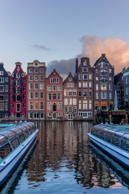 Gün batımında Amsterdam 'daki Damrak Kanalı dans evleri manzarası