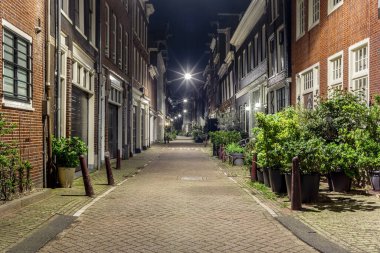 Amsterdam 'da gece geç saatlerde geleneksel mimarisi olan tipik bir kaldırım taşı şeridi.