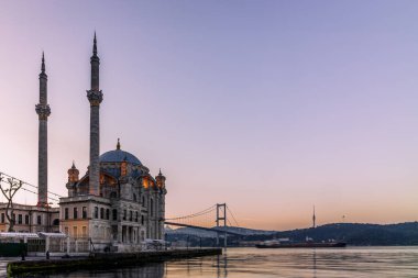 Sabahın erken saatlerinde İstanbul 'daki Ortakoy Camii' nin arka planda hareket eden bir konteynır gemisiyle uzun süre açıkta kalması