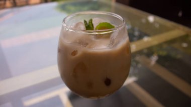 Buzlu sütlü kahve ve berrak bardakta kafein.