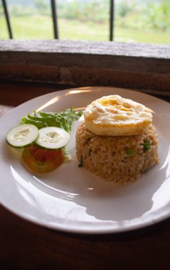 Kızarmış yumurta ve taze sebzeli Endonezya usulü kızarmış pilav.