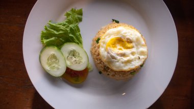 Kızarmış yumurta ve taze sebzeli Endonezya usulü kızarmış pilav.