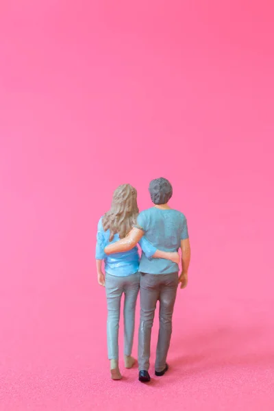 迷你型的男人和女人穿着休闲装站在一起 粉红的背景 情人节的概念 — 图库照片