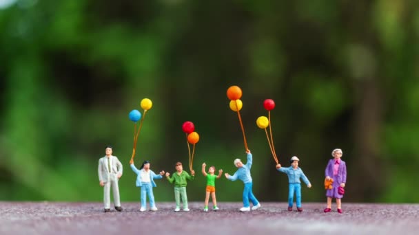 Miniatyr Människor Lycklig Familj Som Innehar Färgglada Ballonger Happy Familjekoncept — Stockvideo