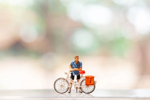 Miniature people standing with bike, World bicycle day concept