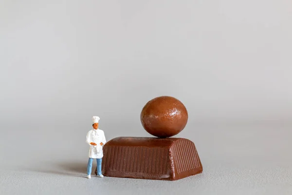 Persone Miniatura Chef Con Cioccolato Piedi Mentre Piedi Uno Sfondo — Foto Stock