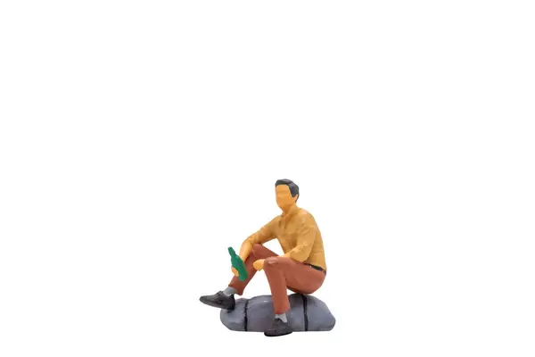 Miniaturní Lidé Mladý Muž Sedí Skále Izolované Bílém Pozadí Výstřižkem — Stock fotografie