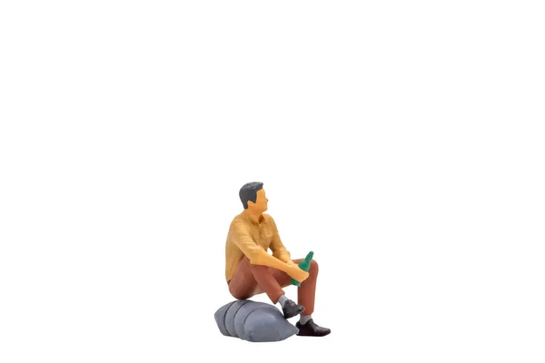 Miniaturní Lidé Mladý Muž Sedí Skále Izolované Bílém Pozadí Výstřižkem — Stock fotografie