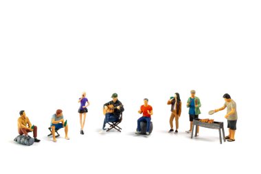 Minyatür insanlar barbekü yapıyor, içecekler içiyor, hatıralar yaratıyor ve beyaz arka planda izole bir şekilde gülüyorlar.