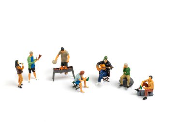 Minyatür insanlar barbekü yapıyor, içecekler içiyor, hatıralar yaratıyor ve beyaz arka planda izole bir şekilde gülüyorlar.