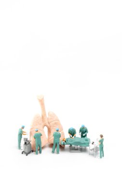 Minyatür insanlar, doktor ve hemşire sağlık ekibi beyaz arka planda acil serviste ameliyat yapıyorlar.