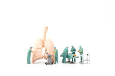 Minyatür insanlar, doktor ve hemşire sağlık ekibi beyaz arka planda acil serviste ameliyat yapıyorlar.