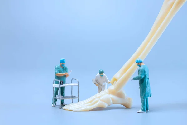 Miniatura Ludzi Model Anatomii Stawu Skokowego Człowieka Lekarzem Niebieskim Tle — Zdjęcie stockowe
