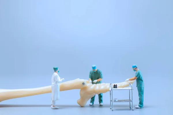 Miniatura Ludzi Model Anatomii Stawu Skokowego Człowieka Lekarzem Niebieskim Tle — Zdjęcie stockowe