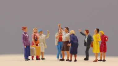 Miniature people , A group of women stand together On a gray backdrop, International Women's Day concept