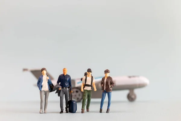 Miniature people, travelers embarks on a delightful vacation, gleefully boarding a tiny airplane , travel and vacations concept.