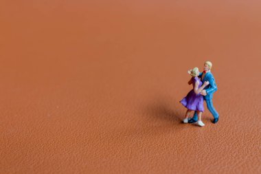 Minyatür insanlar Dansçı çift pürüzsüz kahverengi arka planda