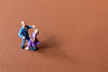 Minyatür insanlar Dansçı çift pürüzsüz kahverengi arka planda