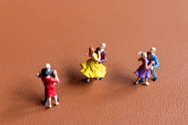 Minyatür insanlar Dansçı çift pürüzsüz kahverengi arka planda