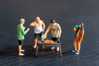 Minyatür insanlar barbekü yapıyor, içki içiyor, hatıralar yaratıyor ve gülüyorlar.