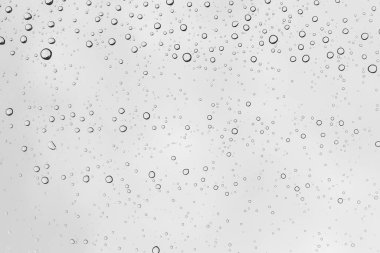 Su damlalarının yakın plan görüntüleri, arka plan camları su damlalarıyla kaplı. Sudaki kabarcıklar