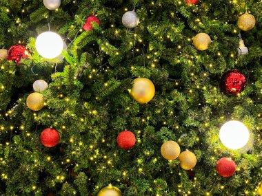 Güzel dekore edilmiş, renkli süslemelerle süslenmiş, sıcak iple aydınlatılmış, neşeli bir tatil ortamı yaratan bir Noel ağacı..