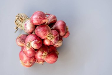 Kurutulmuş samanla bağlanmış taze kırmızı arpacık soğanı. Geleneksel tarım ve organik üretimin sembolü.