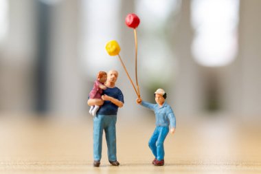 Mutlu çocuklu bir babanın minyatür figürleri. Babalar gününde sevgi, neşe ve kutlamayı simgeliyor.